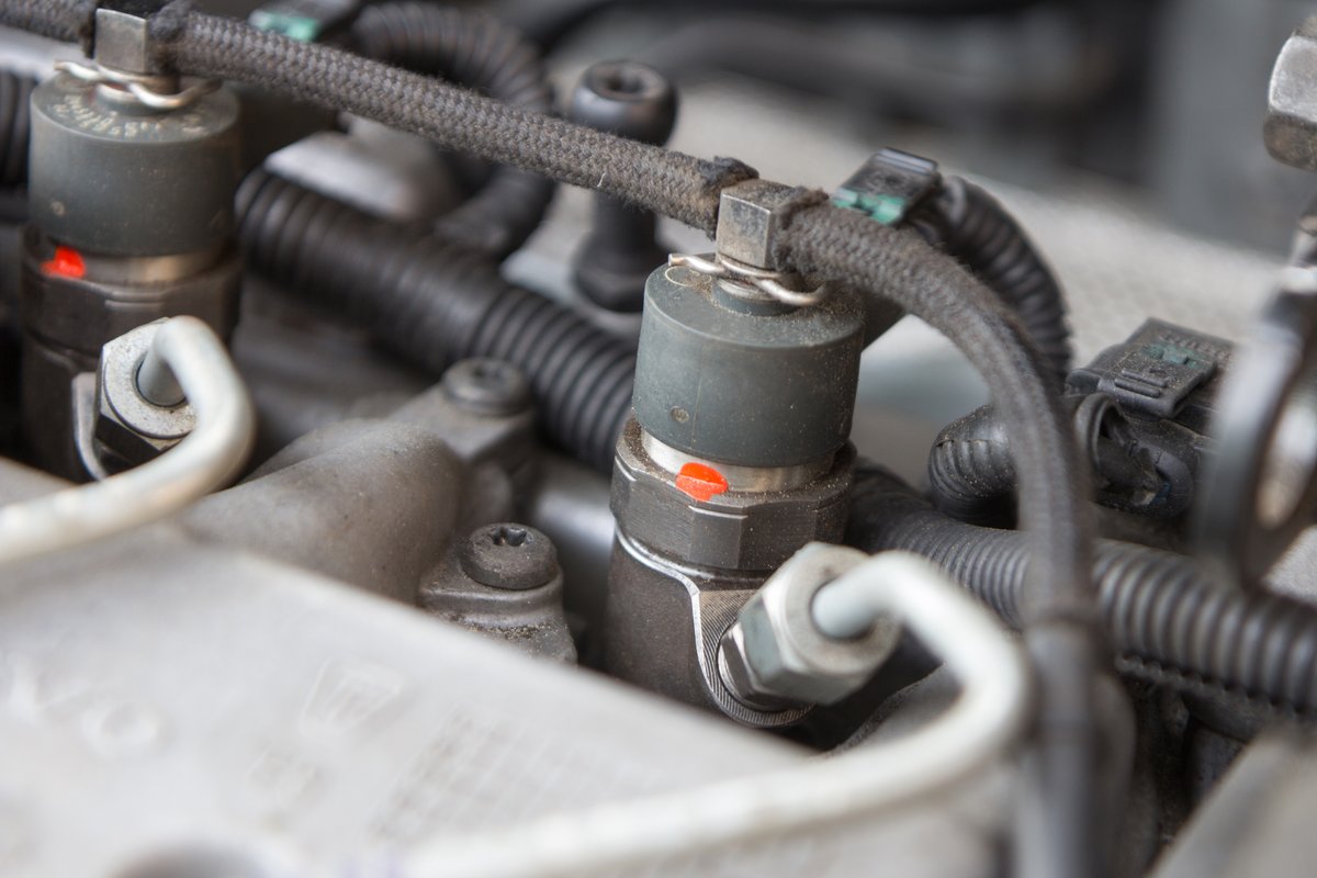 Close view of fuel injectors on an engine intake during a fuel system service