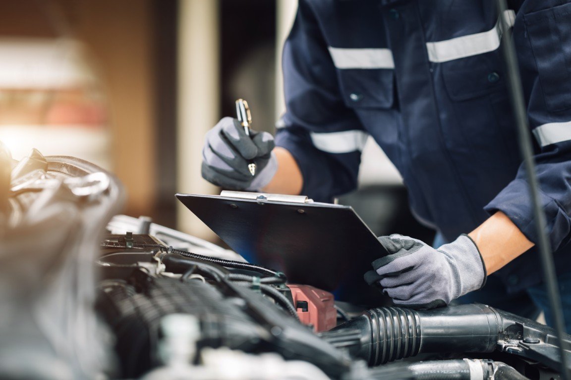 Technician carefully inspecting the engine of a higher-mileage vehicle